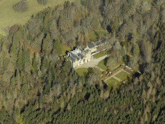 Oblique aerial view centred on the country house, formal garden and stables, taken from the SE.