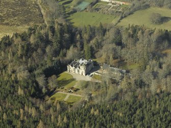 Oblique aerial view centred on the country house, formal garden and stables, taken from the E.