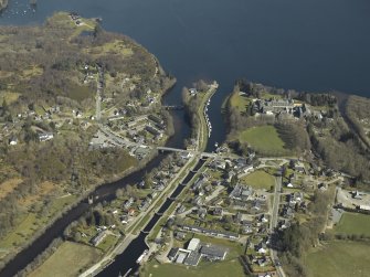 General oblique aerial view of the village centred on the road bridges, swing bridge, locks, abbey and schools, taken from the WSW.
