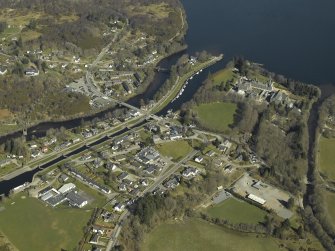 General oblique aerial view of the village centred on the road bridges, swing bridge, locks, abbey and schools, taken from the SW.