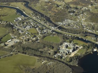 General oblique aerial view of the village centred on the road bridges, swing bridge, locks, abbey and schools, taken from the SE.