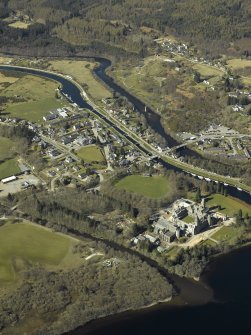 General oblique aerial view of the village centred on the road bridge, swing bridge, locks, abbey and schools, taken from the SE.