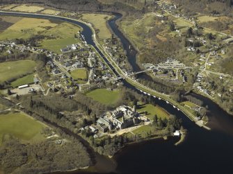 General oblique aerial view of the village centred on the road bridges, swing bridge, locks, abbey and schools, taken from the E.