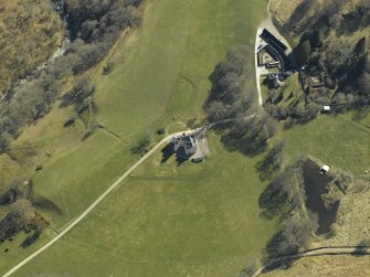 Oblique aerial view centred on the country house, cottage and farmsteading, taken from the NW.