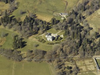 Oblique aerial view centred on the castle and garage with the stables and sawmill adjacent, taken from the SE.