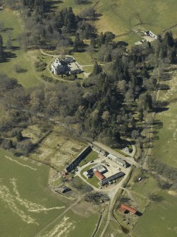 Oblique aerial view centred on the farmsteading, gate-lodge and walled garden with the castle, stable and sawmill adjacent, taken from the E.