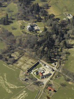 Oblique aerial view centred on the farmsteading, gate-lodge and walled garden with the castle, stable and sawmill adjacent, taken from the E.