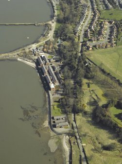 Oblique aerial view centred on the officers' quarters, air raid shelter, stores, boiler house and gym, taken from the W.