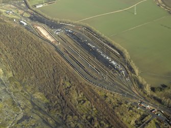 Oblique aerial view centred on railway marshalling yard showing area of former sidings on W side, taken from the SSW.