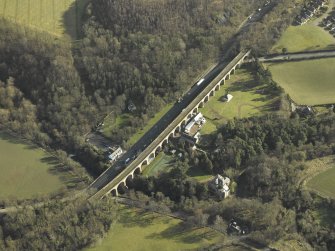 Oblique aerial view centred on Newbattle Railway Viaduct, the Sun Hotel, Lothianbridge, Craigesk House Mill and Damside Cottage, taken from the W.