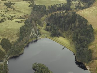 Oblique aerial view centred on the reservoir, dam and cottage, taken from the NW.