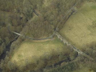 Oblique aerial view centred on the railway viaduct and the road bridge, taken from the NNW.