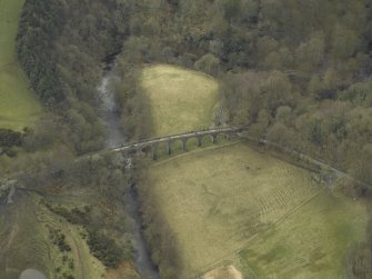 Oblique aerial view centred on the railway viaduct and the road bridge, taken from the N.
