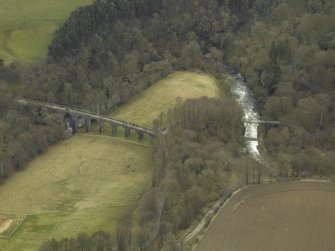 Oblique aerial view centred on the railway viaduct and the road bridge, taken from the NW.