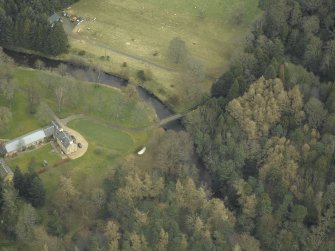 Oblique aerial view centred on the road bridge with the cottage and sawmill adjacent, taken from the WSW.