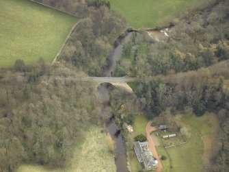 Oblique aerial view centred on the railway viaduct with the house and summer house adjacent, taken from the W.