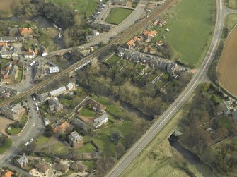Oblique aerial view of the village centred on the road bridges and railway viaduct, taken from the SW.