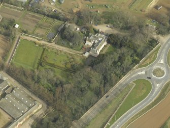 Oblique aerial view centred on the country house with the lodge adjacent, taken from the SW.