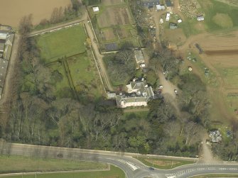Oblique aerial view centred on the country house with the lodge adjacent, taken from the SE.