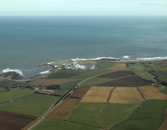 General oblique aerial view centred on the electricity generating station with the farmhouse and farmsteading adjacent, taken from the W.