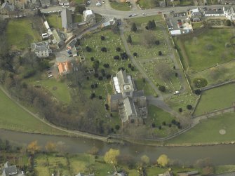 Oblique aerial view centred on the churches and the burial-ground, taken from the E.