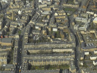 Oblique aerial view of the town centred on the tenement housing with the church adjacent, taken from the SE.