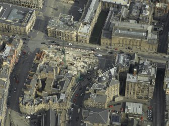 Oblique aerial view centred on the libraries, offices and the construction of the bank and hotel, taken from the SW.