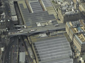 Oblique aerial view centred on the road bridge and railway station, taken from the ENE.