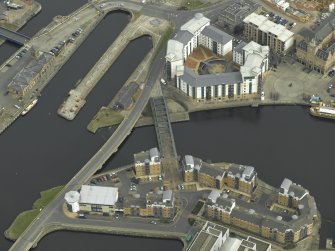 Oblique aerial view centred on the swing bridge, road bridge, harbour, office and dry dock, taken from the WSW.