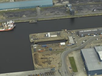 Oblique aerial view centred on the dock and the dry dock, taken from the SW.