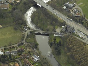 Oblique aerial view centred on the road bridges and cottage, taken from the N.