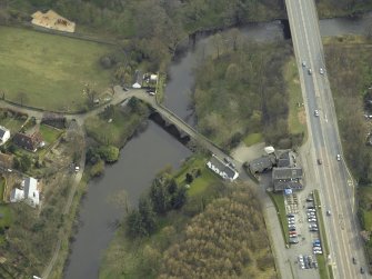 Oblique aerial view centred on the road bridges and cottage, taken from the NW.