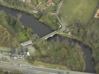 Oblique aerial view centred on the road bridge and cottage, taken from the WSW.