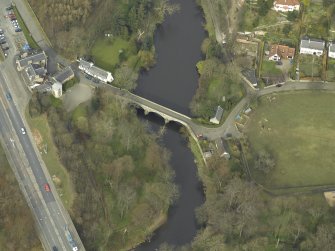 Oblique aerial view centred on the road bridge and cottage, taken from the SSE.