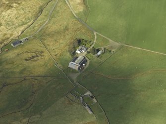 Oblique aerial view centred on the farmsteading and remains of the tower-house, taken from the E.