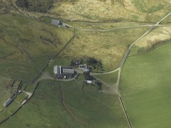 Oblique aerial view centred on the farmsteading and remains of the tower-house, taken from the NE.