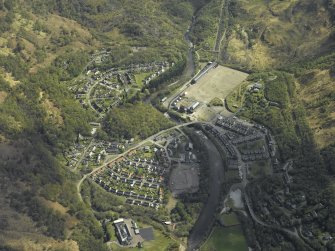 Oblique aerial view centred on the site of the works with the road bridge and church adjacent, taken from the W.