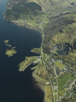 Oblique aerial view of the village centred on the harbour, slate quarries and remains of the fort, taken from the NNW.
