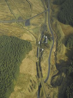 Oblique aerial view centred on Whitrope sidings and cottages, with railway coaches and track panels for the railway preservation Society, taken from the W.