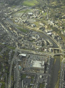 Oblique aerial view centred on the central area of the town on the S bank of the River Teviot, taken from the ENE.