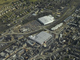 Oblique aerial view centred on the central and former station areas of Galashiels with the almost complete superstores, Tesco and Asda, taken from the NW.