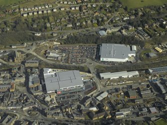Oblique aerial view centred on the central and former station areas of Galashiels with the almost complete Suoerstores, Asda and Tesco, taken from the W.