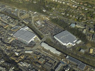 Oblique aerial view centred on the central and former station areas of Galashiels with the almost complete superstores, Asda and Tesco, taken from the SE.