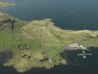 Oblique aerial view centred on the boatyard and the remains of the seaplane base with the house, farmhouse and farmsteading adjacent, taken from the SE.