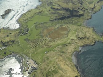 Oblique aerial view centred on the boatyard and the remains of the seaplane base with the house, farmhouse and farmsteading adjacent, taken from the NNE.