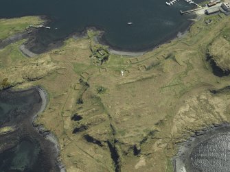 Oblique aerial view centred on the monument and the remains of the ammunition storage huts, taken from the NNW.