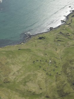 Oblique aerial view centred on the remains of the township with the remains of the dun adjacent, taken from the SE.
