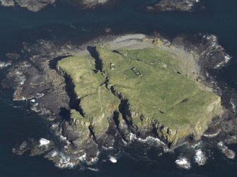 Oblique aerial view centred on the remains of Cairn Na Burgh More Castle, taken from the West.