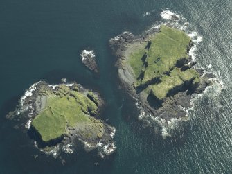 Oblique aerial view of the islands centred on the remains of the castles, taken from the N.