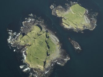 Oblique aerial view of the islands centred on the remains of the castles, taken from the SSW.